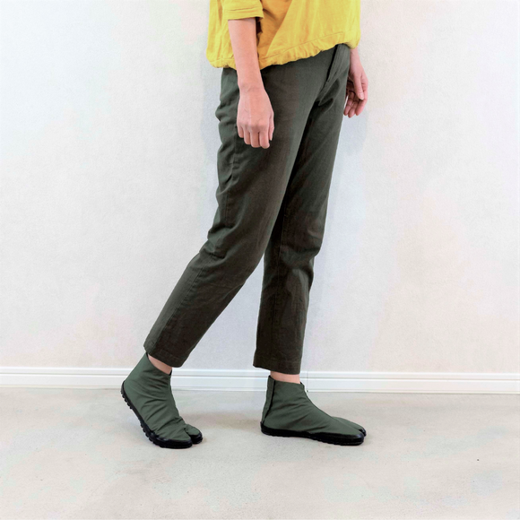 Person wearing khaki Tabi Shoes "U-ten" in a casual standing pose indoors