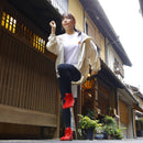 Full-body view of a person wearing red SPORTS JOG II tabi shoes, styled casually in a traditional street setting.
